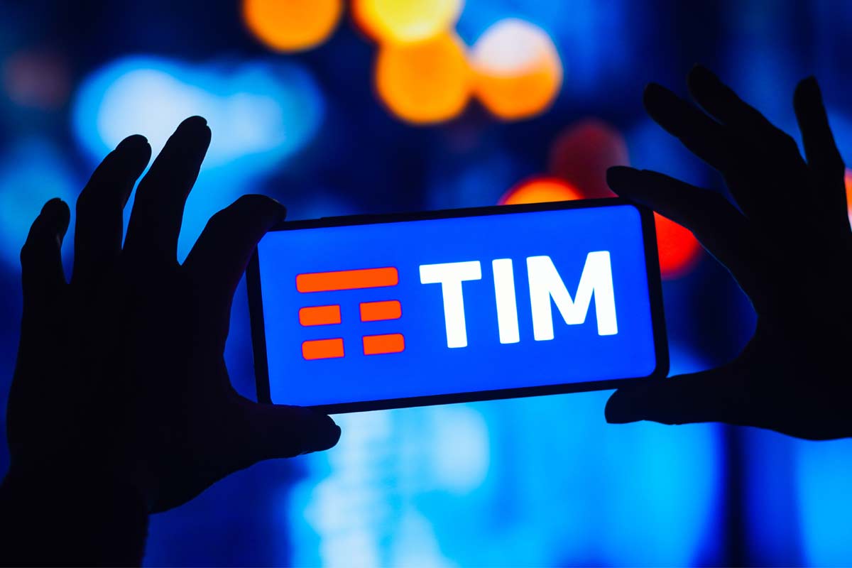logo TIM sullo schermo di uno smartphone tenuto tra le mani