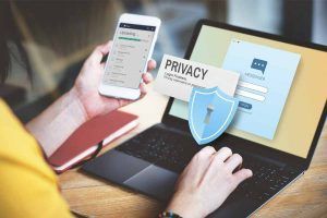 persona con computer e smartphone attenta a privacy