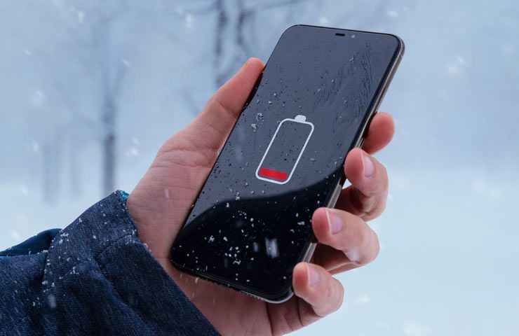 smartphone carica batteria esaurita in paesaggio di montagna innevato