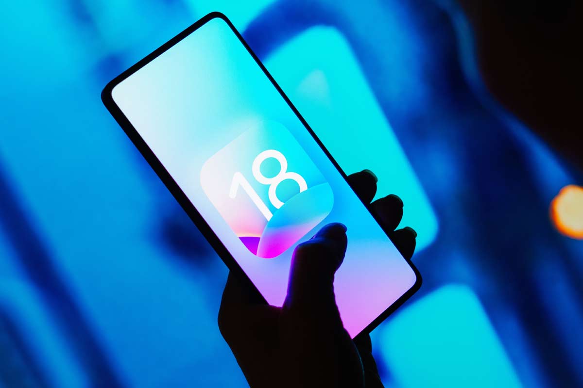 mano tiene in mano smartphone con logo iOS18 non ufficiale