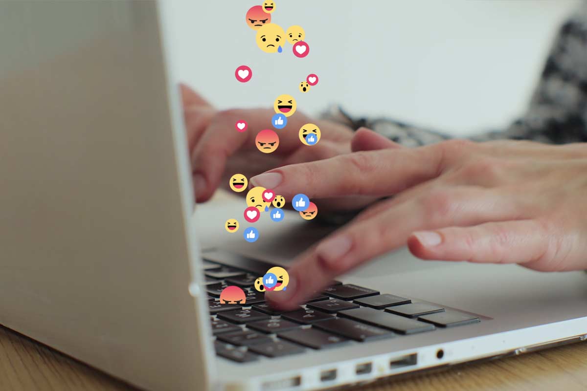 persona scrive al computer, forse una email, usando emoji